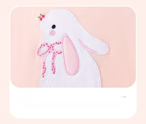 Detail der süßen weißen Kaninchen-Applikationsstickerei auf rosa Baumwolle