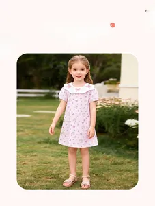 Detail of pink floral toddler dress featuring a white scalloped collar and bow embroidery