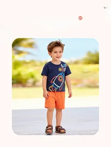 Détail du t-shirt bleu marine avec imprimé fusée et du short orange pour garçons