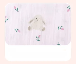 Detailed view of pink floral baby dress fabric with cute rabbit and flower patterns
