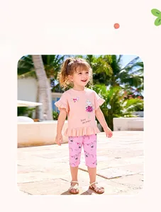 Detail of pink toddler girl summer outfit with ruffled cartoon tee and printed pants