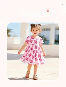 Détail d'une robe rose à manches courtes pour fille avec motifs cerises et nœuds
