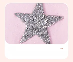 Detailed view of silver star rhinestone pattern on soft pink cotton girl's dress fabric