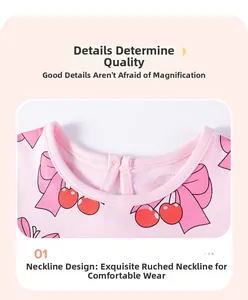 Détail de l'encolure avec motifs cerises et nœuds roses sur un tissu en coton doux