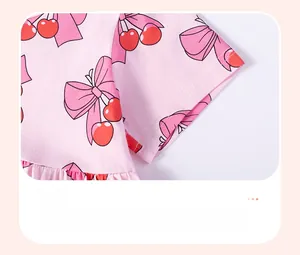 Gros plan du revers de manche rose en coton avec imprimés cerises pour robe de fille