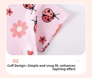 Détail de la manchette en coton rose avec motif de coccinelle et fleurs tricotées