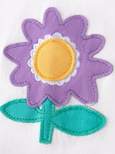 Close-up of vibrant floral embroidery on a white cotton baby girl short sleeve set