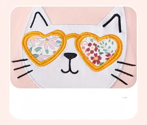 Détail du haut en coton rose avec broderie chat blanc et lunettes aux motifs floraux