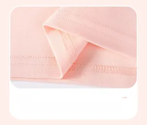 Gros plan détaillé sur les doubles coutures de l'ourlet d'un haut rose pour fille en été