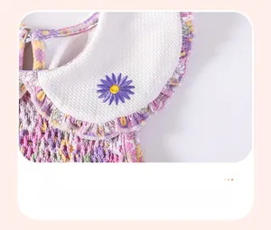 Dettaglio dello scollo dell'abito floreale con ricamo di margherita viola e bordo a volant