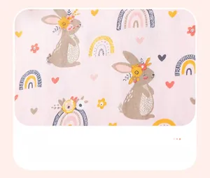Close-up of soft pink knit cotton fabric with cute rabbit, rainbow, and heart prints