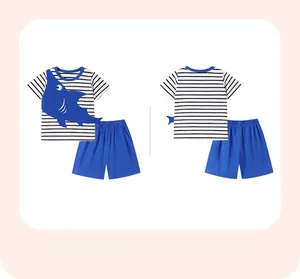 Flat lay of boys summer shark outfit featuring striped short sleeve tee and blue shorts