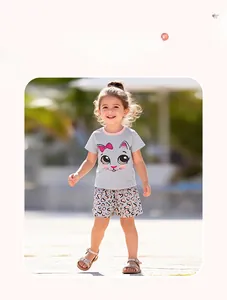 Outdoor model display of girls' summer set with grey cat t-shirt and heart leopard shorts