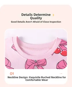Close-up of pink cotton girl's top with cherry print and ribbed neckline detail