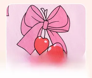 Close-up of pink knit cotton fabric with cute cherry and bow print detail for kids