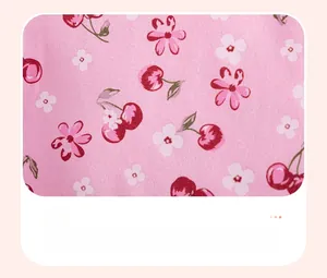 Close-up of pink knit fabric detail featuring cute cherry and floral print patterns