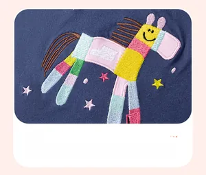 Detailed close-up of colorful horse embroidery and stars on blue cotton girls' dress