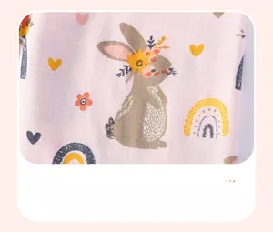 Detailed view of soft pink cotton fabric with cute bunny and rainbow printed pattern
