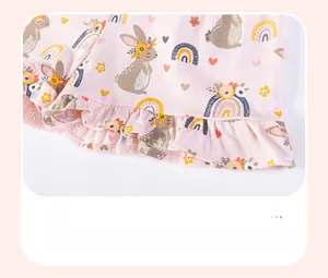 Detail of pink cotton girl's shorts with cute rabbit rainbow prints and ruffled hem