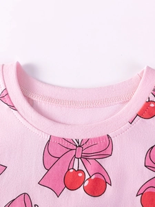 Sweet pink girls' T-shirt with cute cherry and bow print made of soft cotton fabric