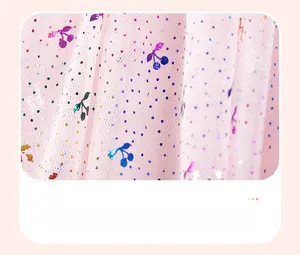 Dettaglio del tessuto in tulle rosa plissettato con paillettes e motivo a ciliegie