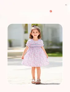 Detail of hand-smocked floral girl's summer dress with colorful embroidery and ruffle sleeves
