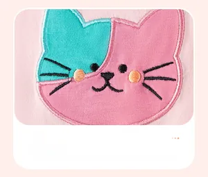 Détail de robe rose pour bébé avec broderie chat en patchwork et finitions nettes