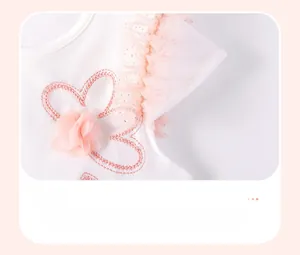 Detail of a white cotton dress featuring layered pink tulle cuffs with silver glitter accents