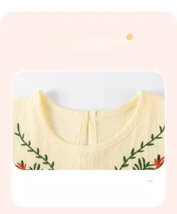 Close-up of crew neck design with green vine and orange floral embroidery on beige cotton