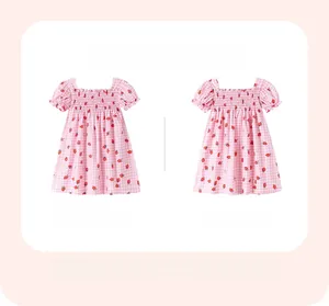 Détails avant et arrière d'une robe pour fille avec vichy rose et motifs fraises