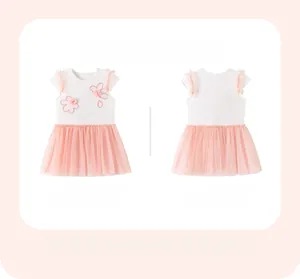 Detail of pink tutu dress with floral embroidery and mesh flutter sleeves on white cotton