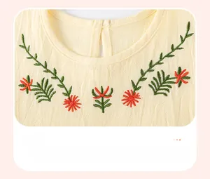 Close-up of floral embroidery and natural wrinkled texture on beige cotton dress