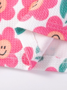Abito estivo da bambina in tessuto a nido d'ape con fiori rosa e bordo con volant fine