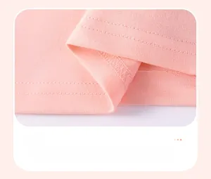 Détail de l'ourlet en tricot de coton rose montrant la qualité de la double couture