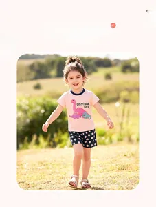 Detail shot of toddler girl summer outfit with pink dinosaur tee and polka dot shorts