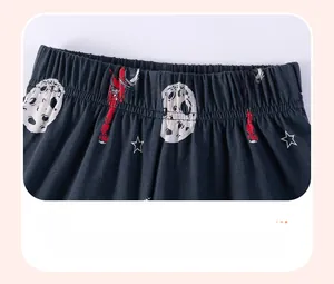 Detail of elastic waistband on dark navy boys' shorts with cartoon space pattern