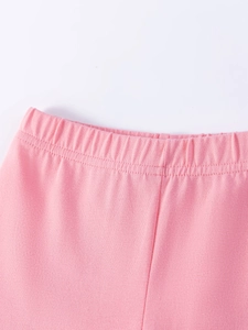 Gros plan d'un short enfant en coton rose avec taille élastique sur fond blanc épuré