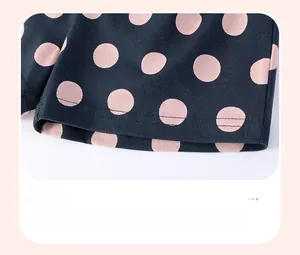 Close-up of baby girl shorts featuring pink polka dots on black soft cotton fabric