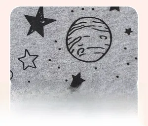 Detail of star and planet prints on gray knitted cotton fabric for boys' summer outfit