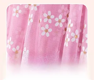 Gros plan détaillé du tissu en tulle rose avec fleurs blanches et texture plissée