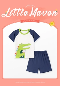 Detail of boys summer cotton set featuring cartoon crocodile print and blue shorts