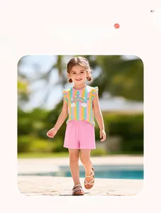 Mädchen Sommer-Set mit Regenbogen-T-Shirt und rosa Shorts im Freien am Pool