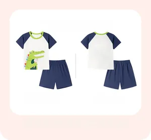 Flat lay of boys white and navy cotton summer set featuring cartoon crocodile print