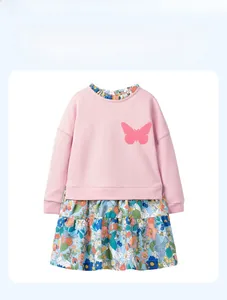Détail de robe fille à manches longues avec appliqué papillon et jupe fleurie rose