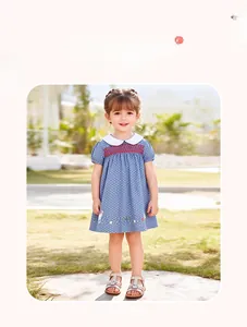 Detail of smocked neckline and floral rabbit embroidery on girl's polka dot dress