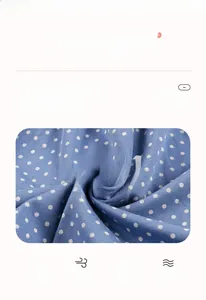 Close-up of blue polka dot cotton fabric showing breathable texture and soft knit weave