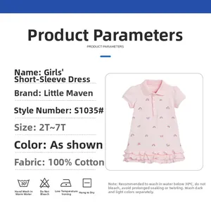 Détail de la robe en coton rose pour fille avec motifs arc-en-ciel et ourlet à volants