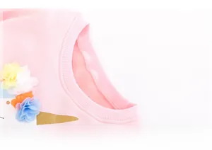 Dettaglio maglietta rosa a maniche lunghe con scollo a coste e decorazioni floreali 3D