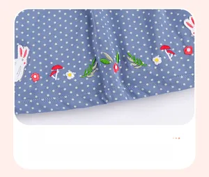 Close-up of cotton dress hem with rabbit embroidery and white polka dots pattern