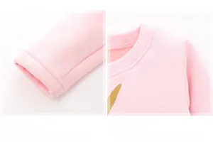 Dettaglio macro della maglia rosa in cotone con scollo a coste e stampa dorata